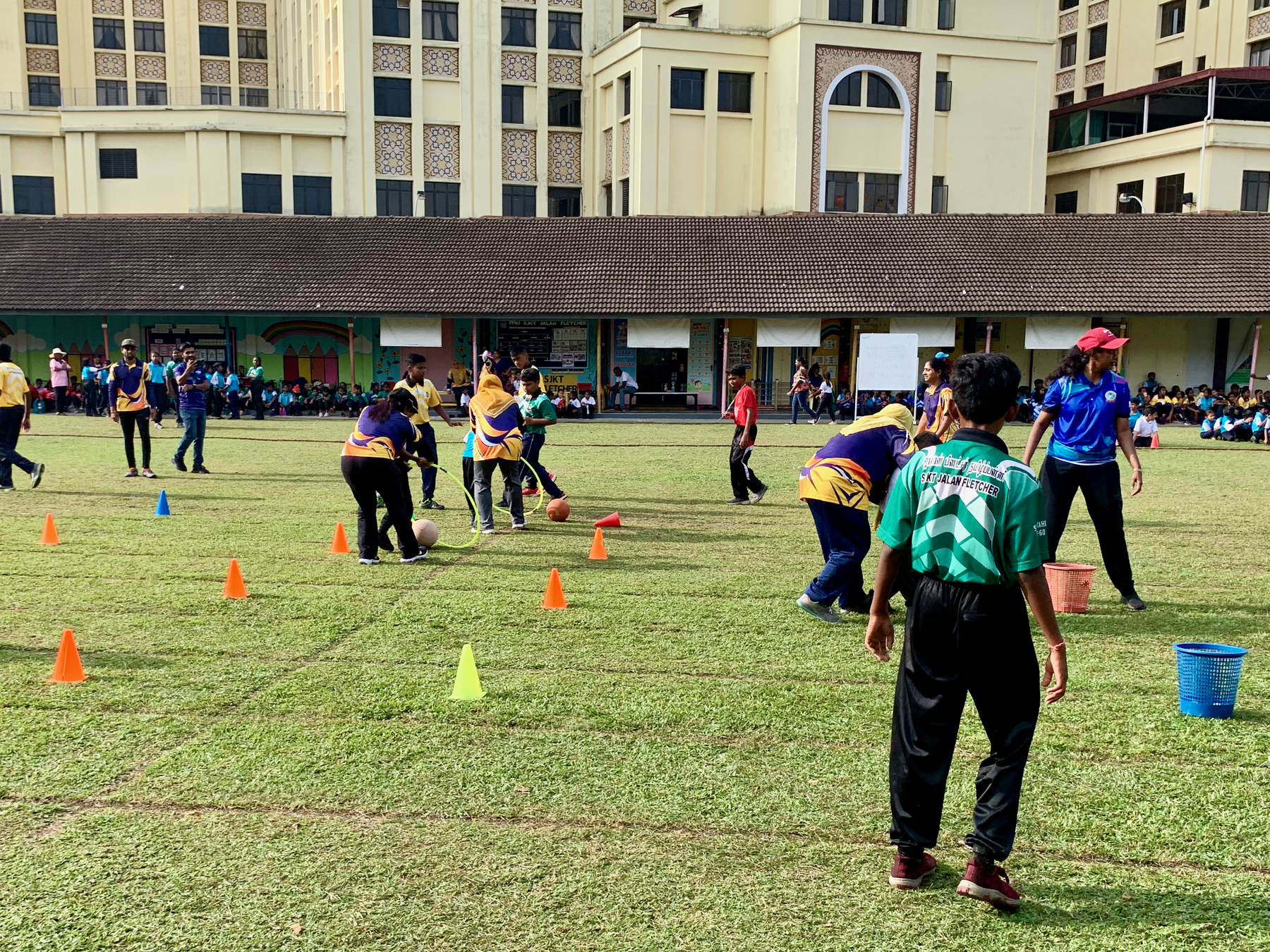 School ground where in a game some chldren are guided by teachers