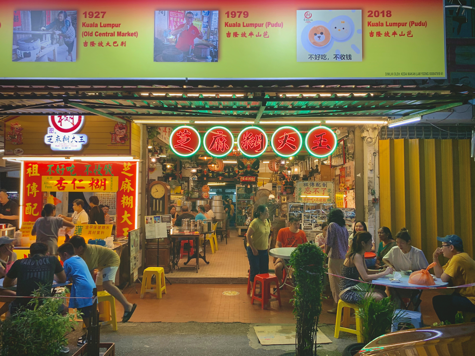 A neon lit, old school dessert shop with seating on the pavement